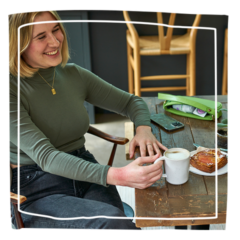 Women having a coffee with eczema visible on her hand