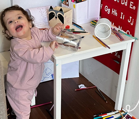 Girl playing with pens with eczema on face 