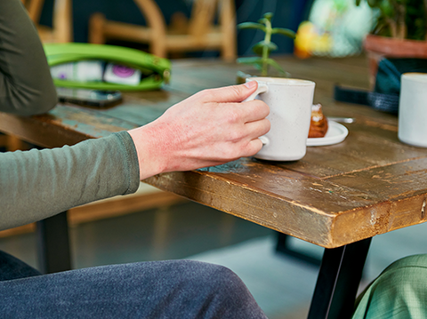 Eczema on a women's hand with a coffee mug