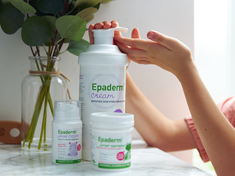 Epaderm cream and ointment on the side with a childs hand