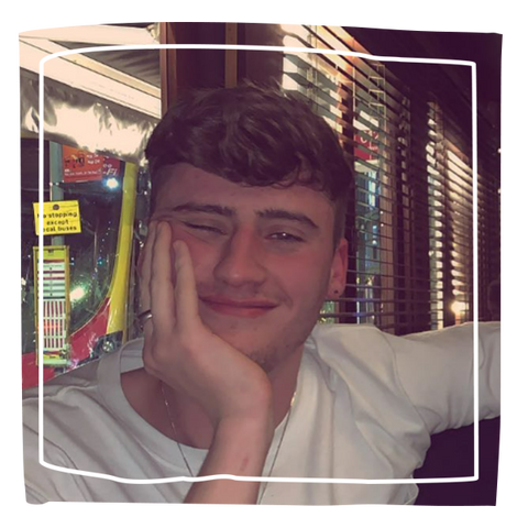 Man smiling at camera resting his face on his hand
