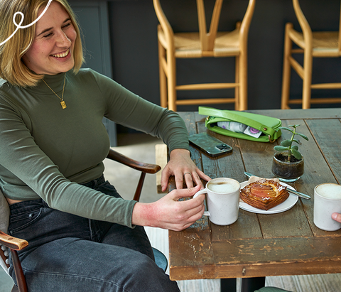 women having a coffee with eczema on her hand