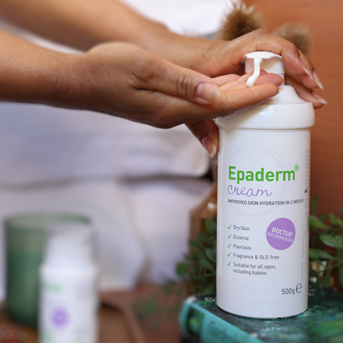 Person holding a bottle of Epaderm Cream with a blurred background