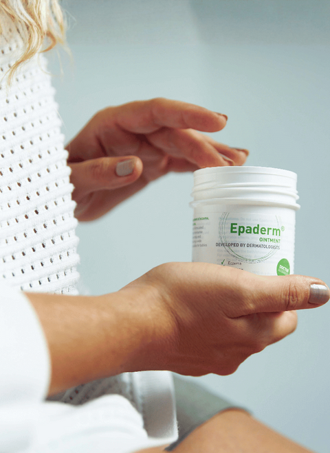 Person holding Epaderm Ointment  against a light background
