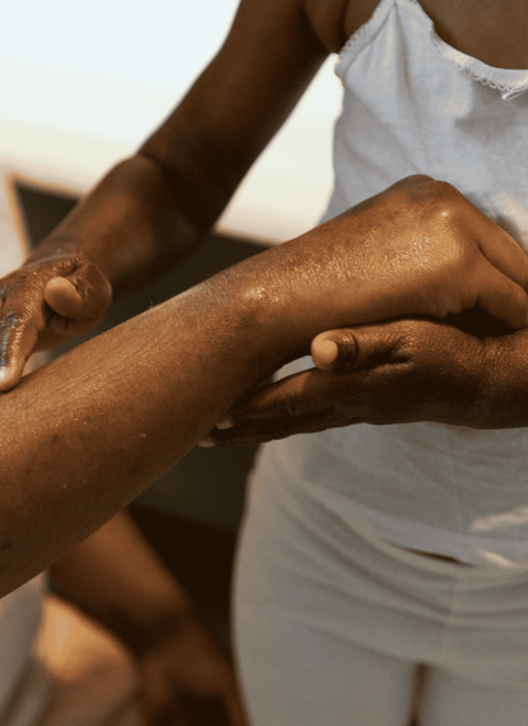 Close-up of two people holding hands with a blurred background