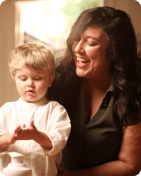 Woman and child interacting indoors with a warm, soft focus background